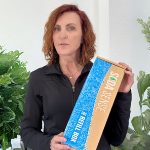 A satisfied customer holding a Soda Sense refill box, content with the company's quick and efficient mail-in CO2 canister exchange service.